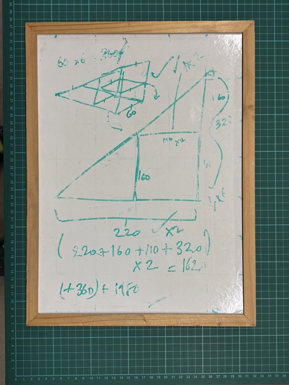 Photograph of whiteboard with sketched dimensions for artwork 'Greasy Bouffant' with calculations for required timber purchase quantity